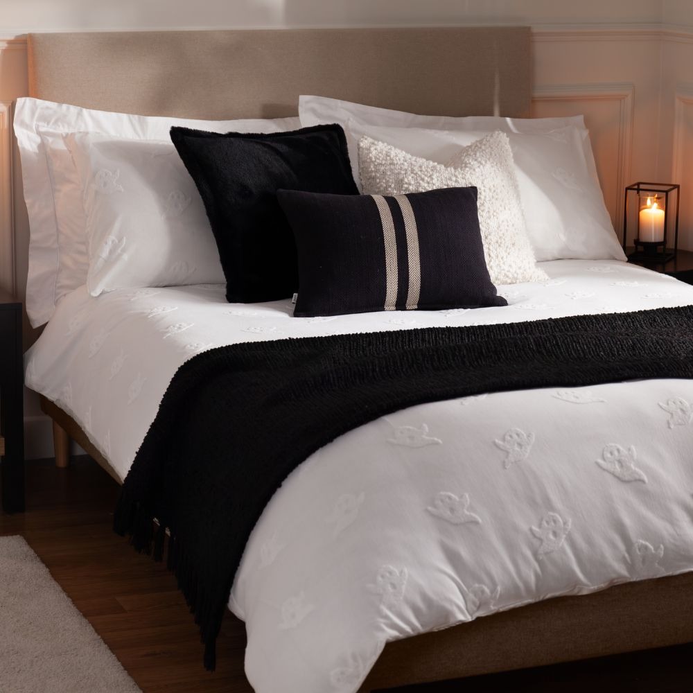 monochrome bed with white tufted ghosts, a black throw and black and white cushions