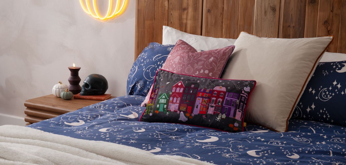 navy halloween bedding, with a halloween cushion and a cream and pink cushion