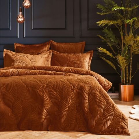 bed with rust quilted palmeria duvet set on
