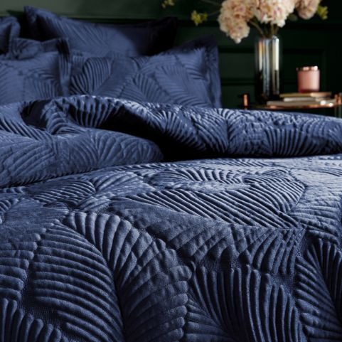 bed with deep navy blue quilted duvet set on