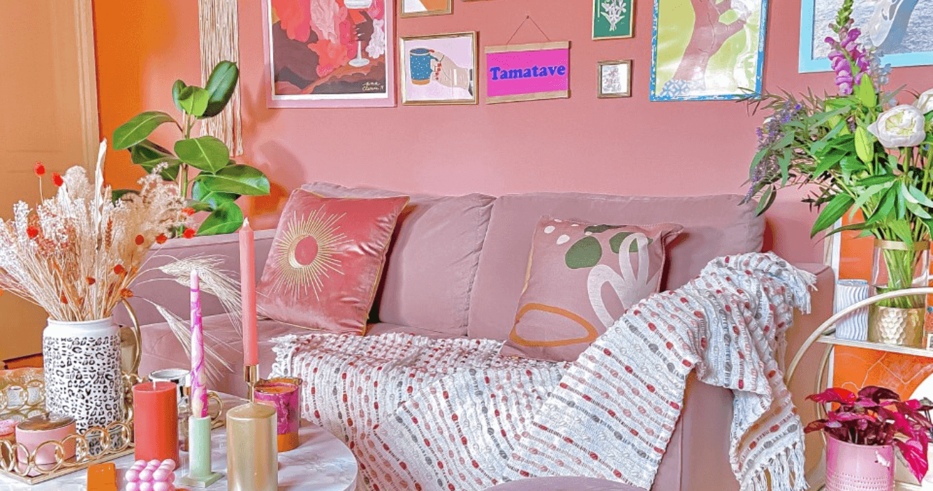 a pink living room filled with pink home decor accessories, like pink cushions, throws and candles. 