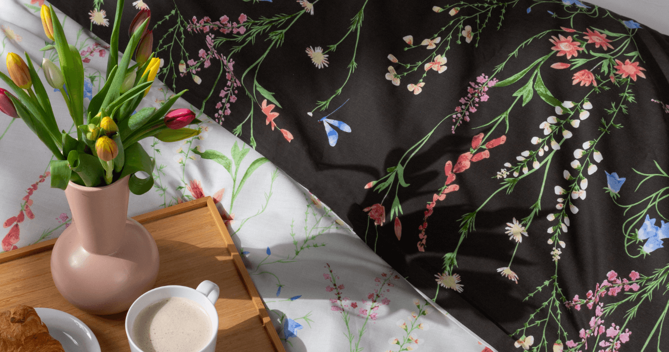 breakfast in bed for mother's day, with yellow and red tulips and black floral bedding