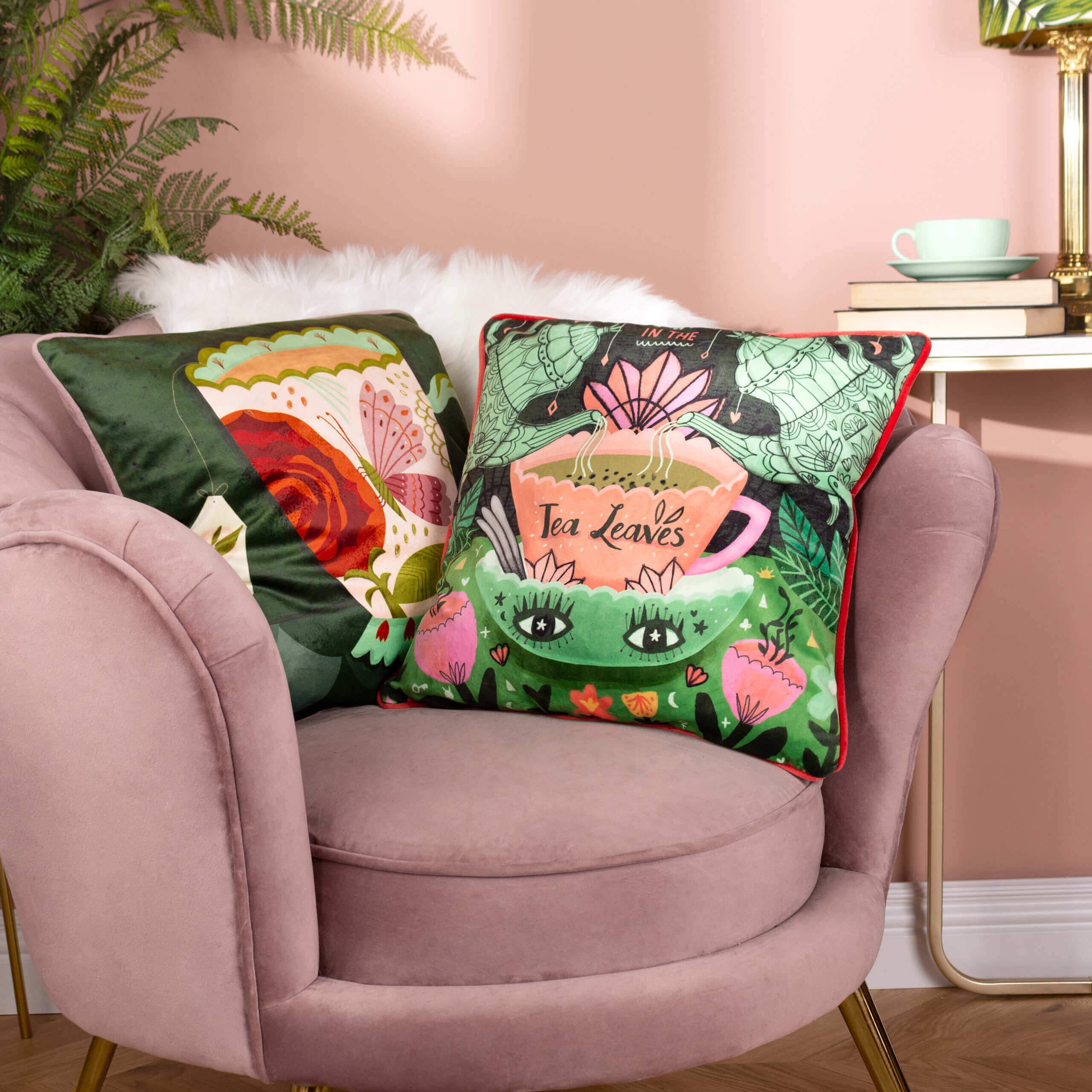 two illustrated cushions from Kate Merritt on a pink velvet chair 