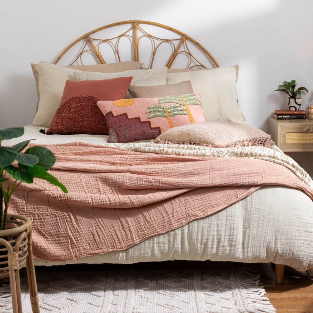 A boho-style bedroom decorated with a neutral muslin duvet set, a blush crinkle cotton throw, and multiple boho scatter cushions.