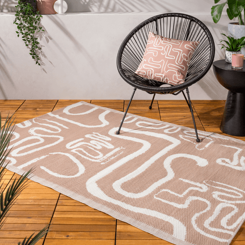 beige rug with an abstract design on it on wooden decking
