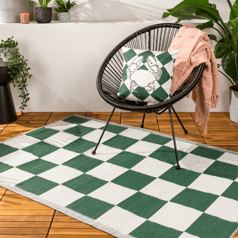 green and white checked outdoor rug with garden chair on top