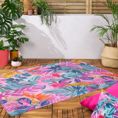 multicolour floral outdoor rug on wooden decking with plant next to it