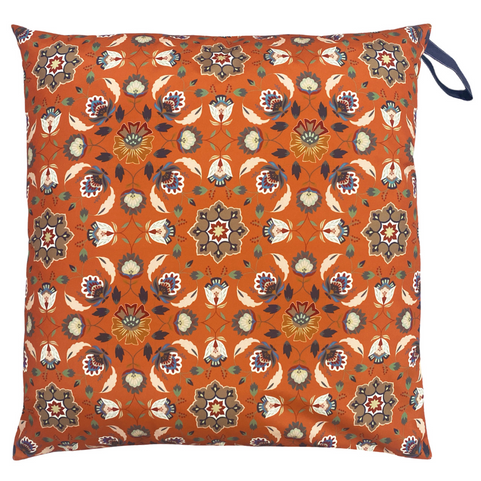 a large orange floor cushion printed with a folk inspired geometric pattern.