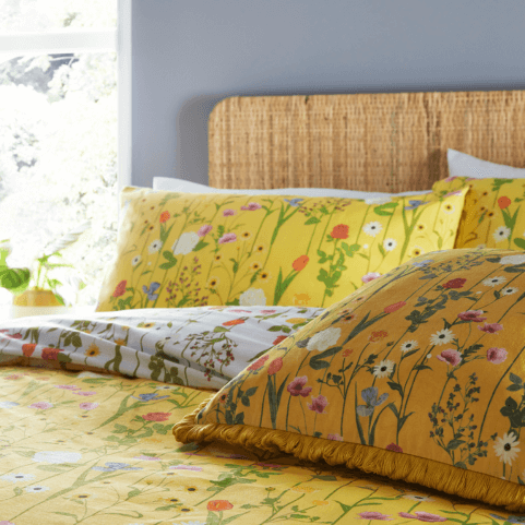 a yellow floral duvet cover set with a matching white reverse, printed with illustrations of various spring flowers.