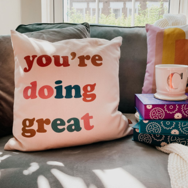 A 100% recycled cushion with a slogan design reading 