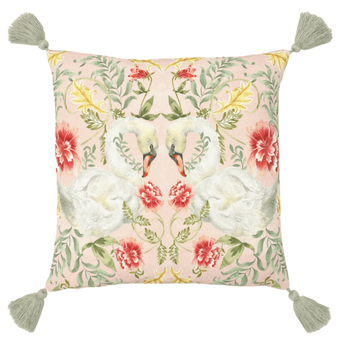 a cushion with tassels at each corner, with a symmetrical swan design surrounded by flowers and vines on the front.