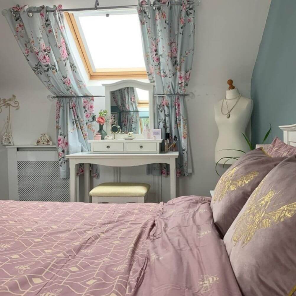 A country take on granny chic decor, with floral curtains, a bee-themed bedding and soft pastel colours. 
