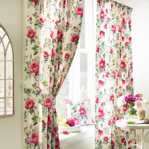 a set of floral curtains at the window, featuring a white background and pink flowers.