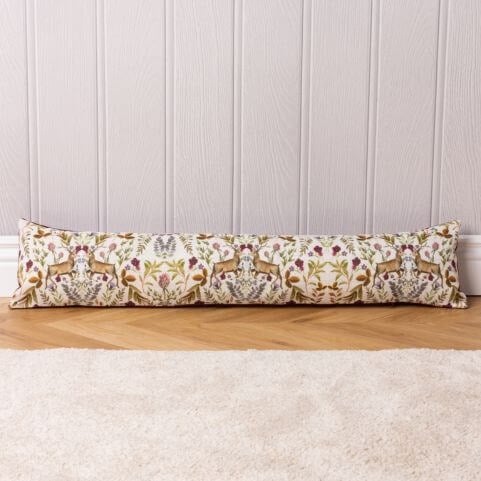 a draught excluder with a busy pattern of stags and florals