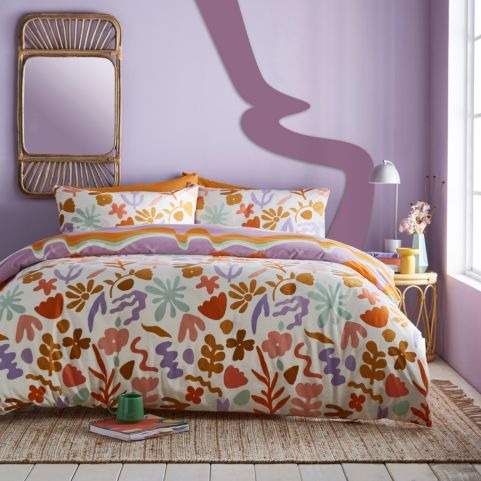 A lilac bedroom with a modern graphic floral pattern on the bedding. 