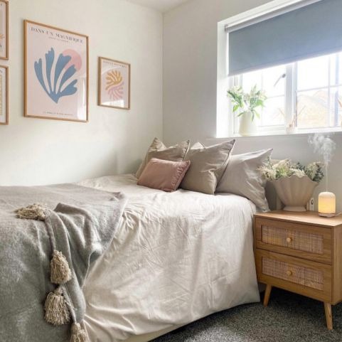 a relaxed style bedroom with cream and grey bedding, and lots of natural cushions.