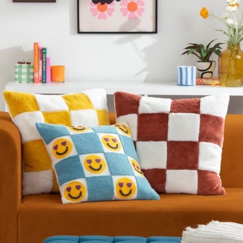 A yellow sofa matched with a range of brightly coloured cushions in yellow, red and light blue tones.