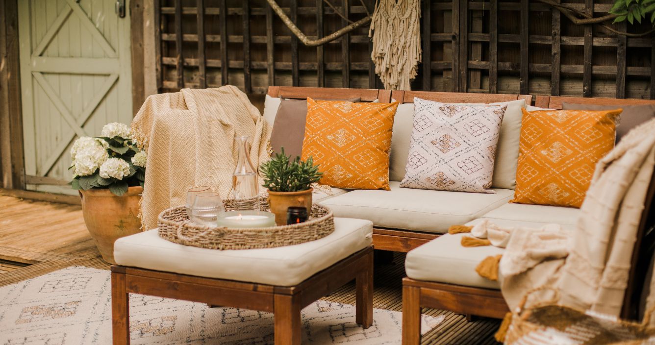 An outdoor space with a range of boho style cushions on an outdoor sofa. 