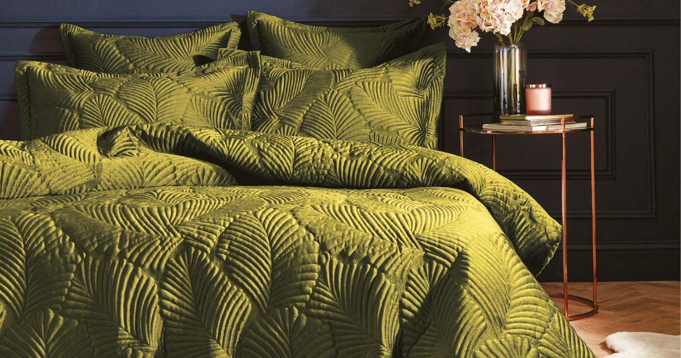 A moss green duvet cover set with an embroidered floral design.