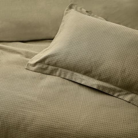 A cotton waffle duvet cover set in an olive green shade, photographed from an aerial view.