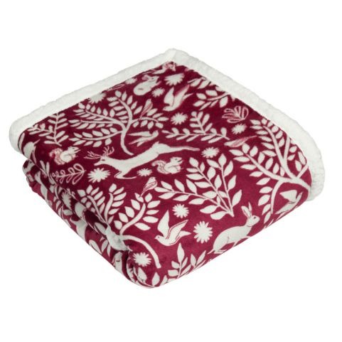 A red fleece throw with a Scandi-inspired festive design of woodland animals and florals.