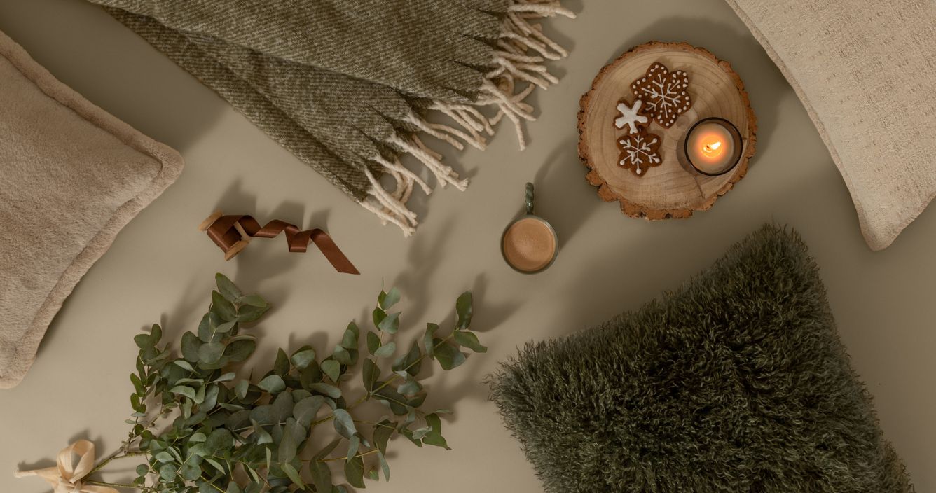 Christmas gifts with a cosy throw, blanket, cushion and a candle all in shades of green