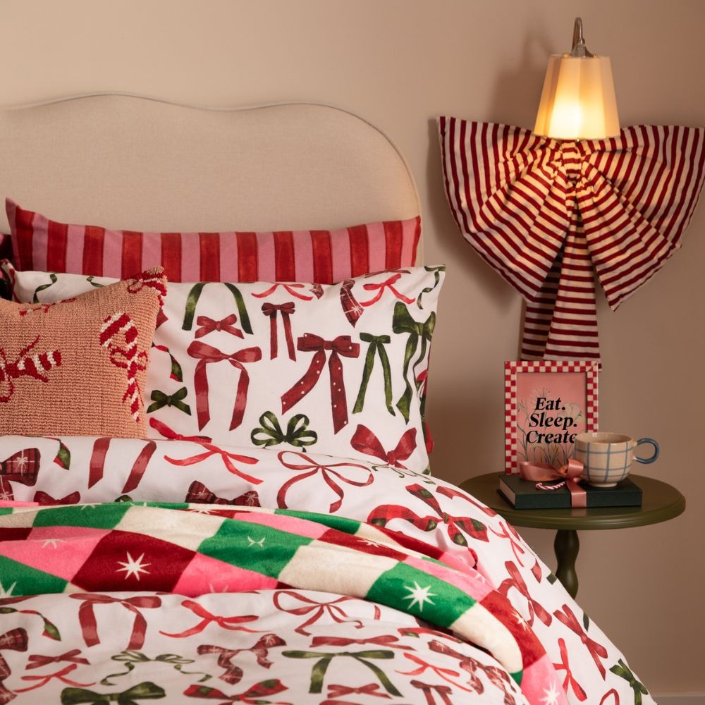 A Christmas duvet cover set featuring red and green festive bows on a white background.