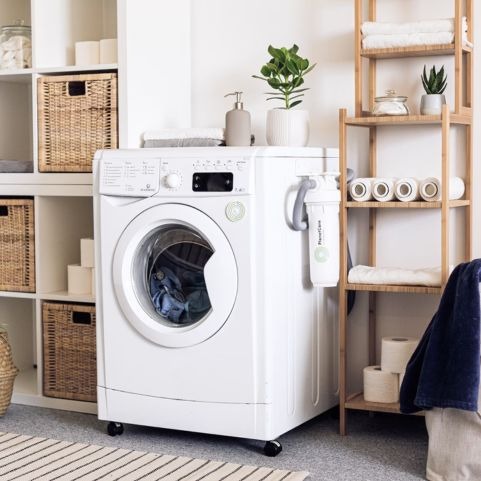 washing machine in laundry room next to a rug
