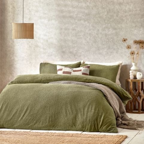 olive boucle bedding with minimalist cushions and throws