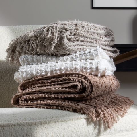 minimalist woven throws in neutral shades in a pile