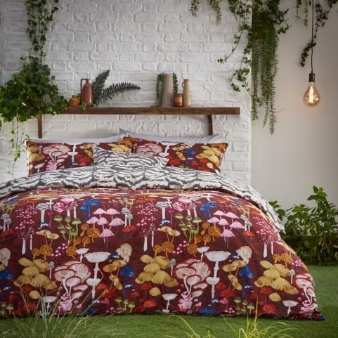 mushroom maximalist duvet set on bed with grass surrounding
