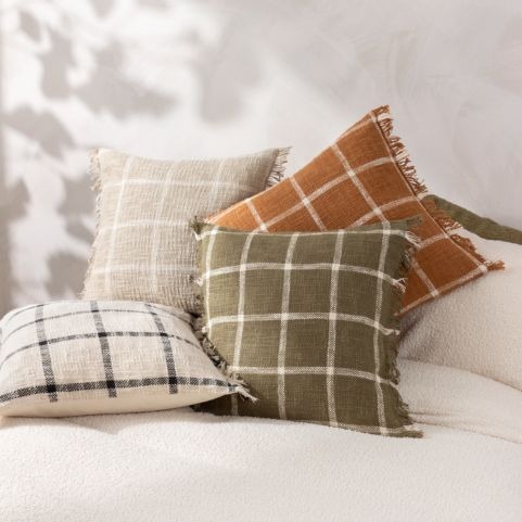 pile of scandi style cushions in various neutral colours
