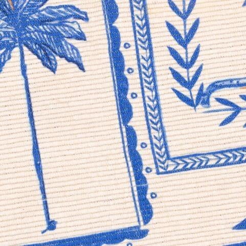 A closeup image of an indoor/outdoor polyester rug with a Greek-inspired abstract design in blue and white shades.