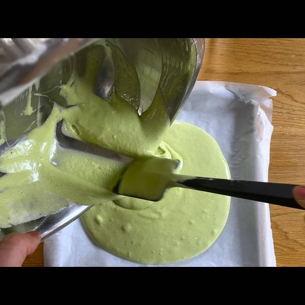 Adding the cake batter onto the sheet pan