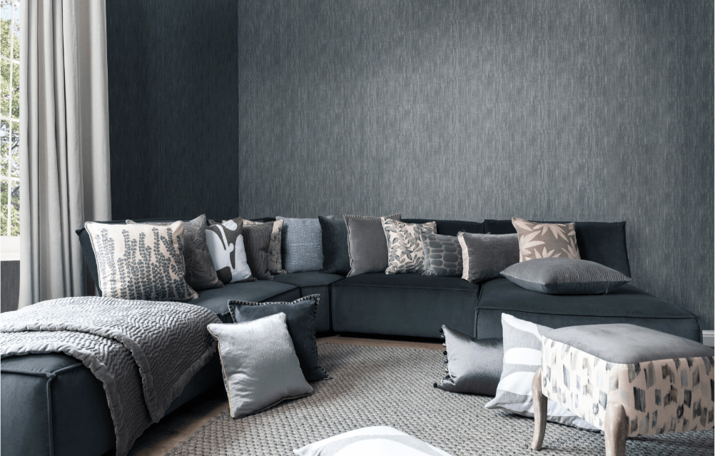 Neutral sofa cushions arranged for maximum comfort on a dark grey sofa.
