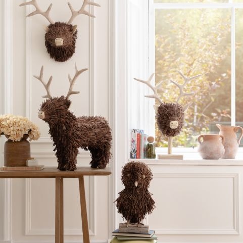 A collection of wooden animal sculptures next to a window