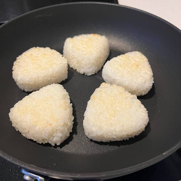 One side of the onigiri, turning golden brown