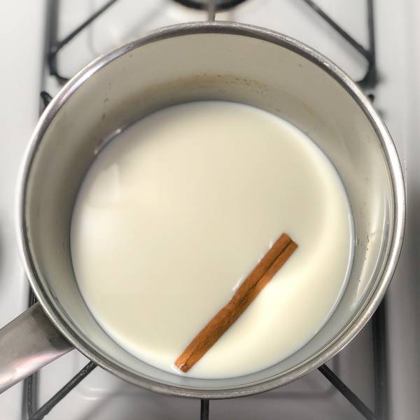 Simmering the milk and cinnamon stick in a pot