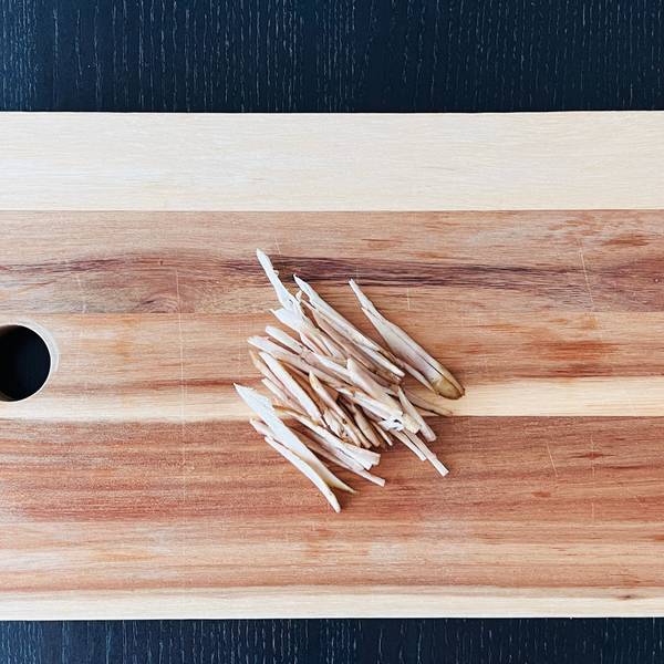 sliced burdock root pieces on a cutting board