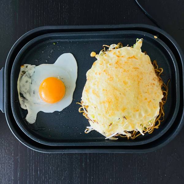 cooking the egg next to the okonomiyaki