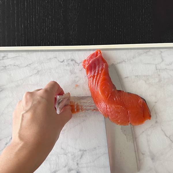 Separating the salmon skin from the meat