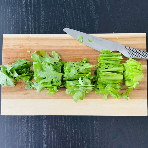 cutting chrysanthemum greens into bite-sized pieces