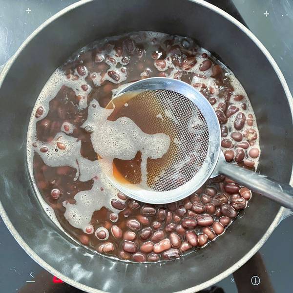 skimming the scum from the surface of the beans