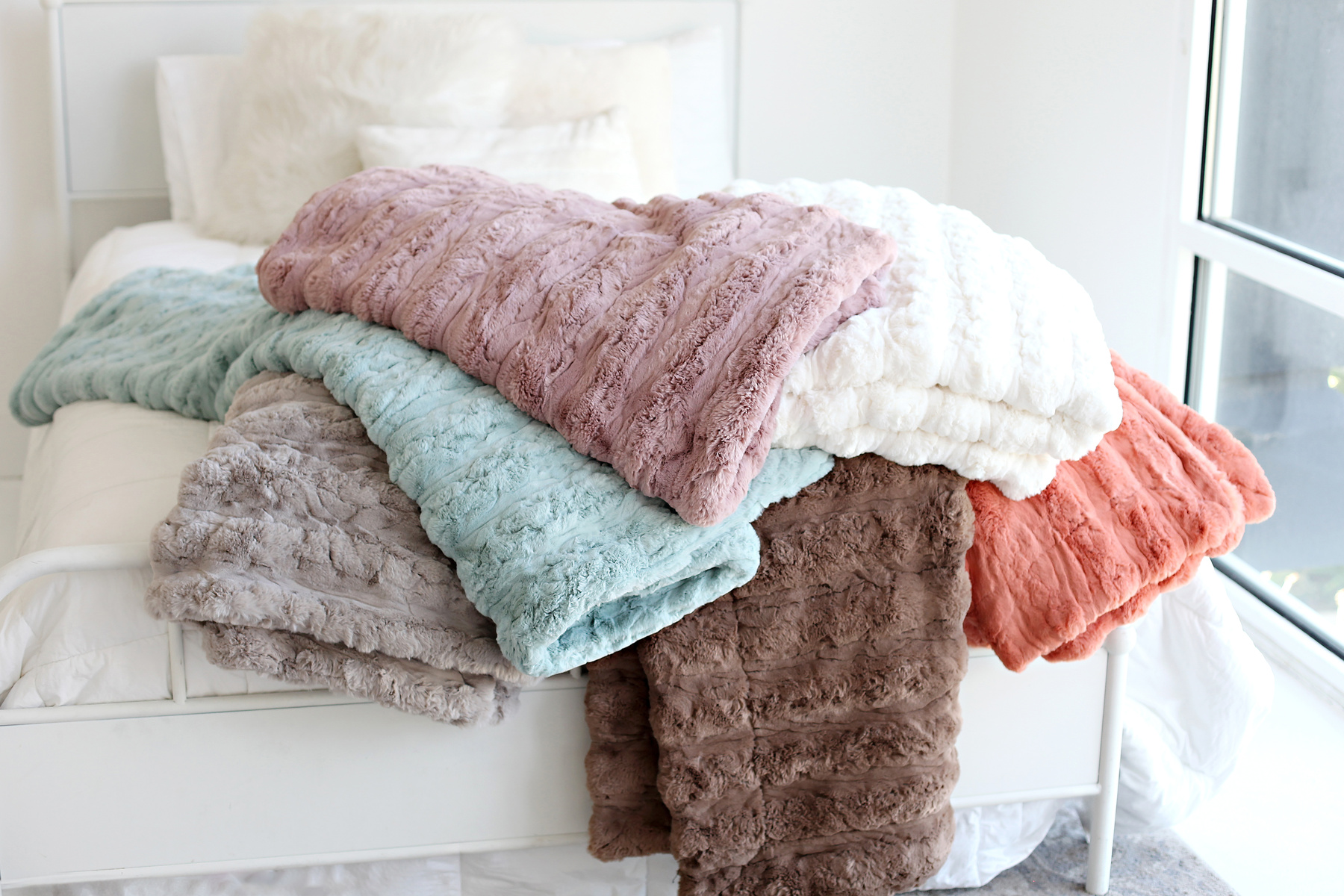Stack of soft blankets showing how to clean a weighted blanket and keep it fresh
