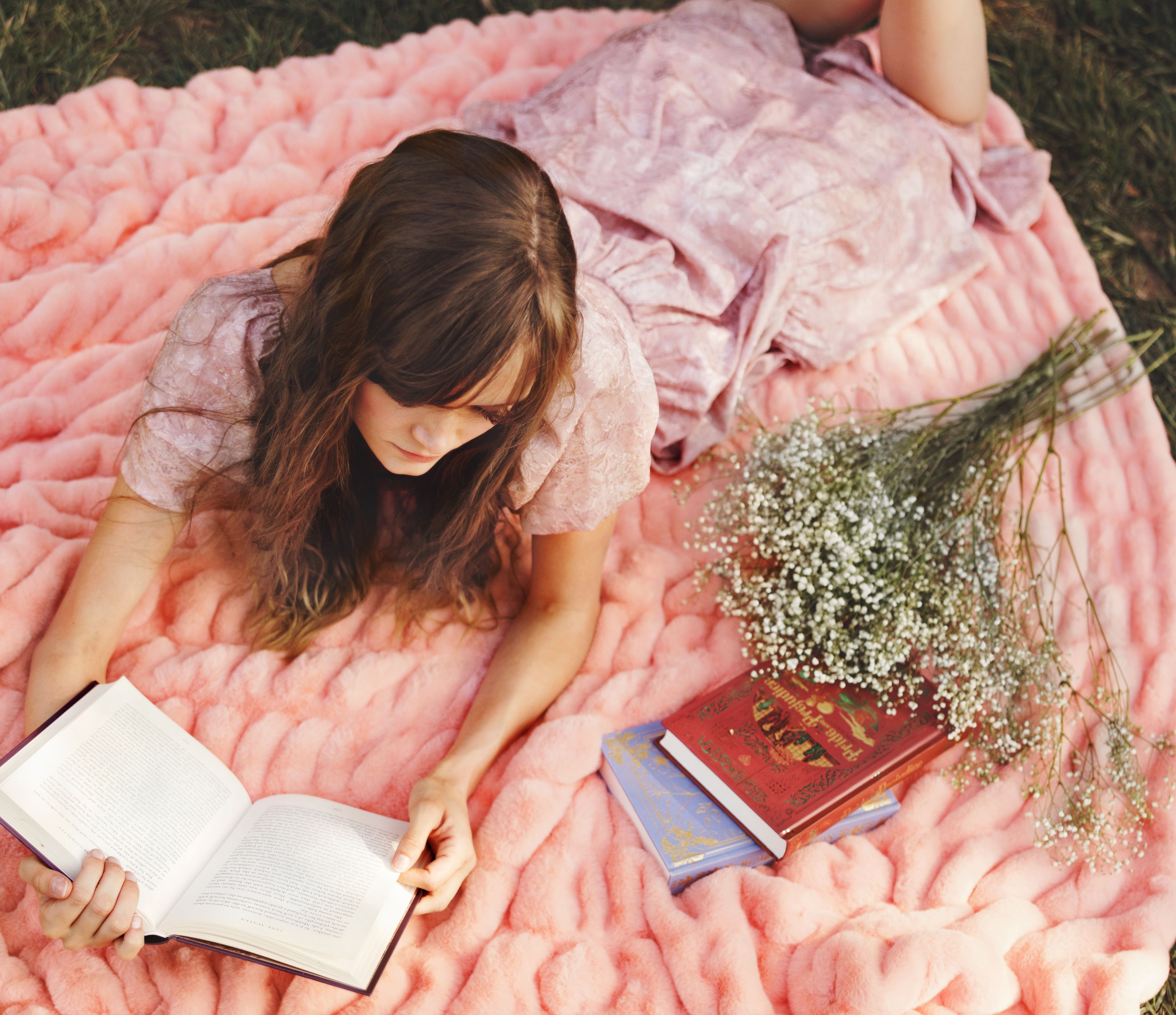 Woman relaxing with soft spring bedding ideas and layered pink textures in a cozy bedroom 