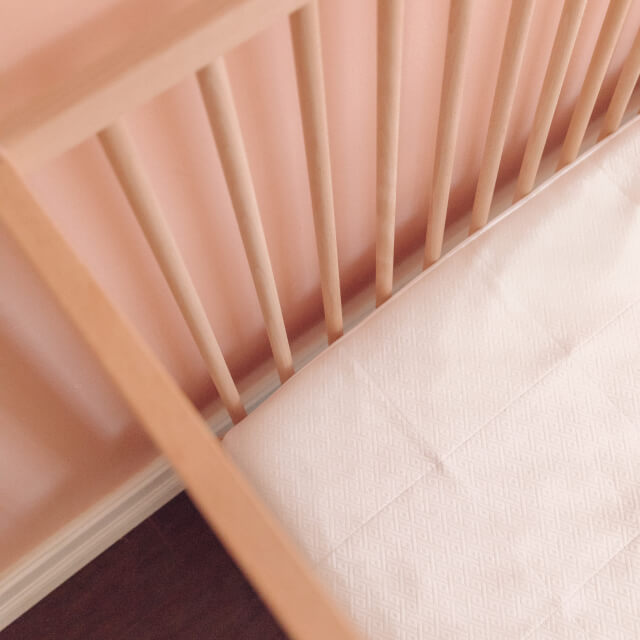 A view of a child’s crib from above with the Slumber Cloud Core Mattress Protector - Crib