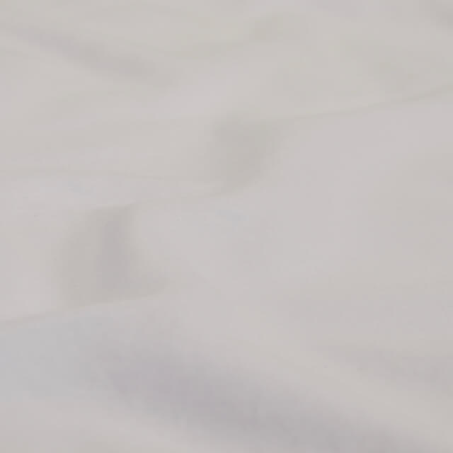 A detailed view of the fabric on the Slumber Cloud Essential Fitted Sheet - Crib in white