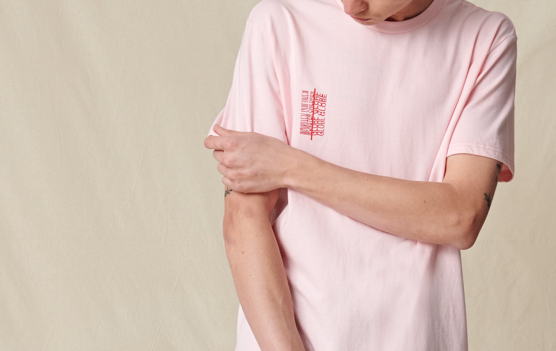 man wearing globe refuse bubble gum pink tee