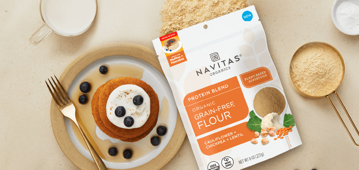 Plate of pancakes made with Navitas Grain-Free Flour next to unopened package of Navitas Grain-Free Flour