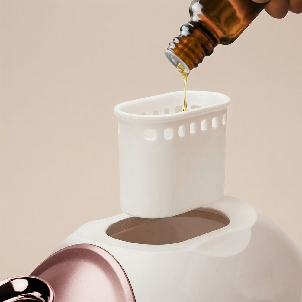 Woman using rivo facial steamer with essential oil compartment